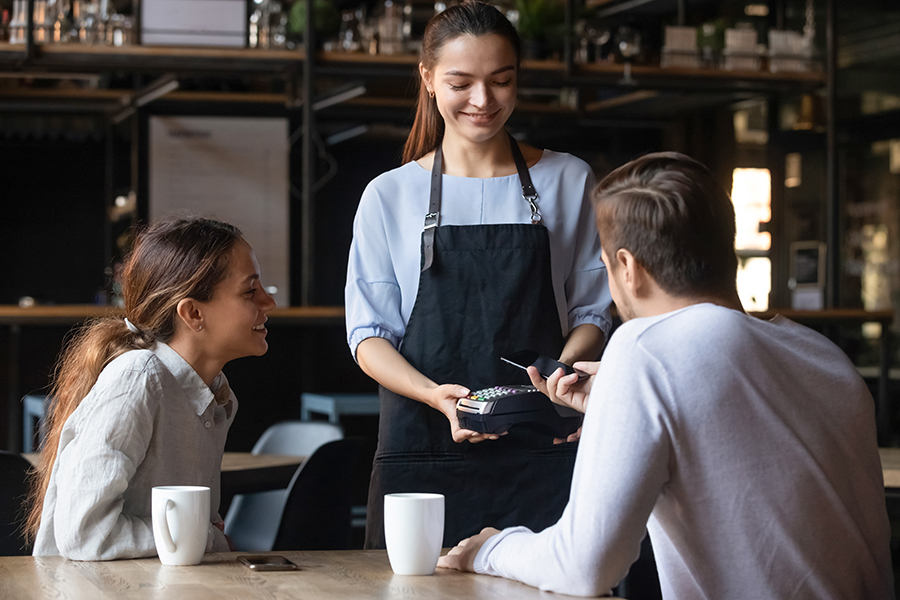 Diverse couple buyers male female pub bar client pay bill order use cellphone smartphone app near field communication system. Modern fast easy tech NFC contactless payment, food drink industry concept